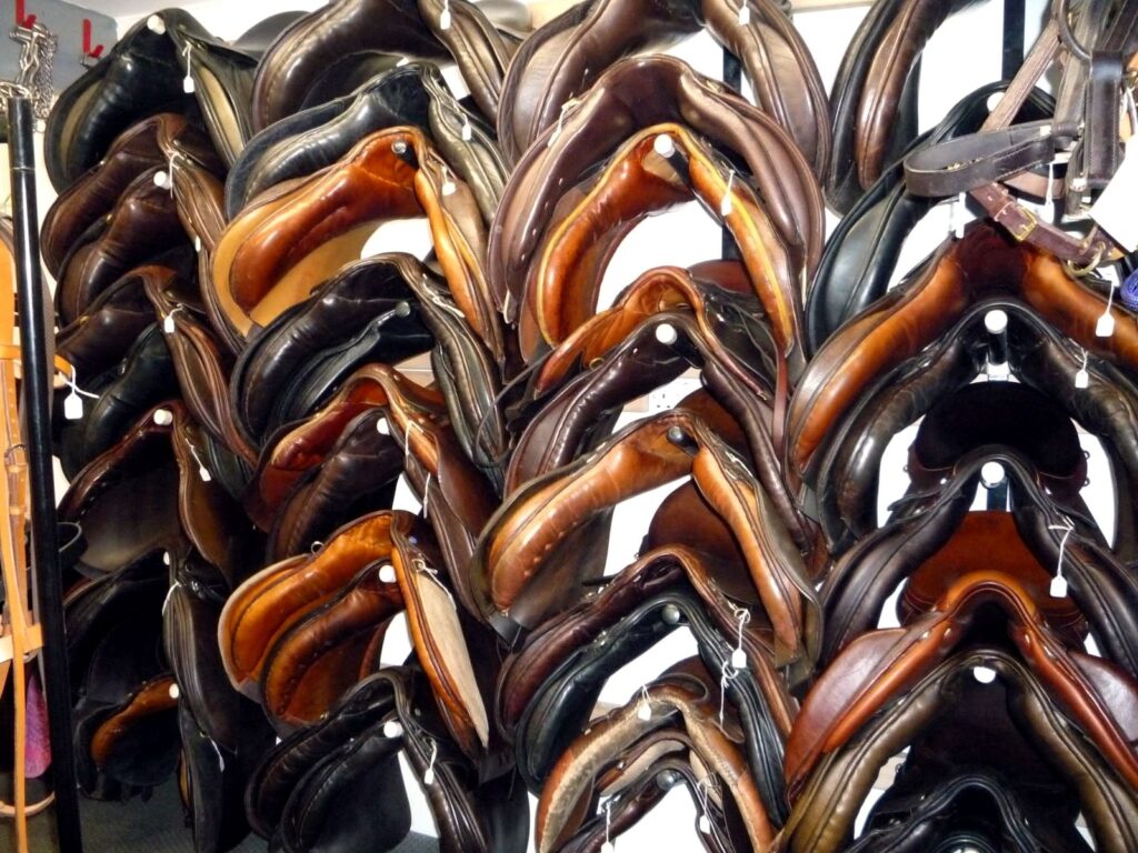 Rack of second-hand saddles for sale at The Newark Saddler