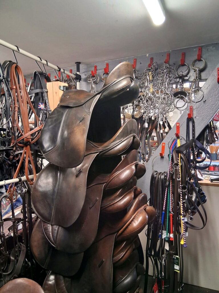 Stacked used saddles at The Newark Saddler in Newark